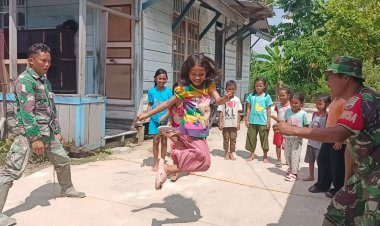 Personil Satgas Memanfaatkan Waktu Istirahat Bermain dengan Anak - anak di Lokasi TMMD